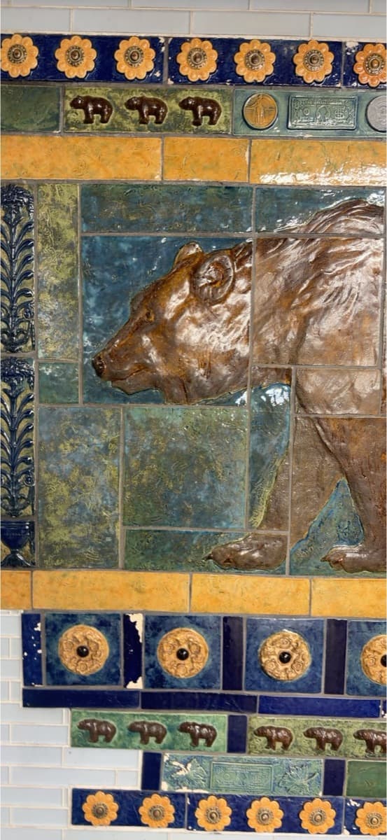 A glazed ceramic bear on a subway station wall